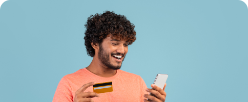happy-indian-guy-holding-cell-phone-credit-card 1