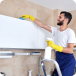 man-cleaning-kitchen-surface-high-up-standing-ladder-cleaning-service-concept.png